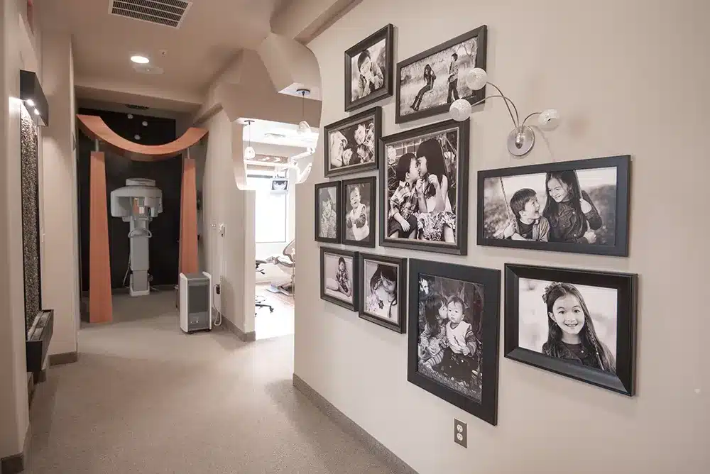 Hallway with multiple pictures against the wall of our dentist in Plano and team.