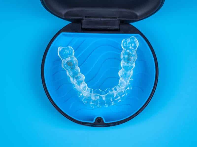 A patient's undergoing Invisalign treatment in Plano, TX, aligner in its case